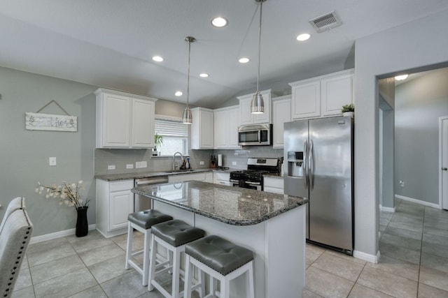 kitchen with a sink, appliances with stainless steel finishes, backsplash, and visible vents
