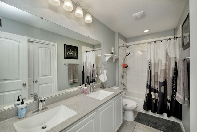 bathroom featuring a sink, tile patterned floors, shower / bath combo, and toilet