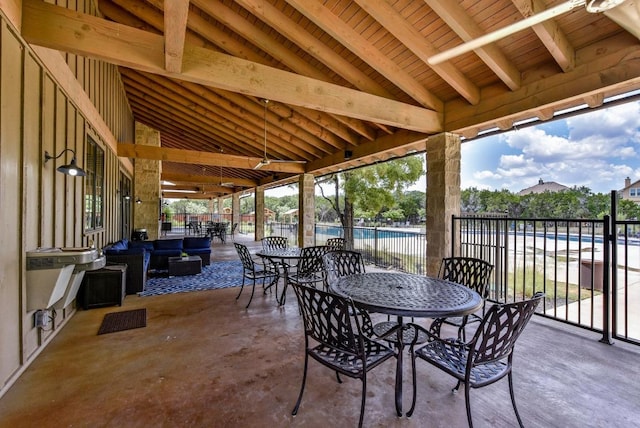 view of patio / terrace featuring a community pool, fence, outdoor dining area, and outdoor lounge area