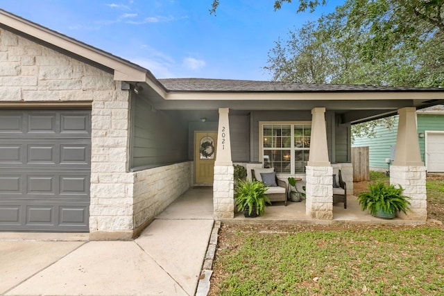 doorway to property with covered porch, an attached garage, and stone siding