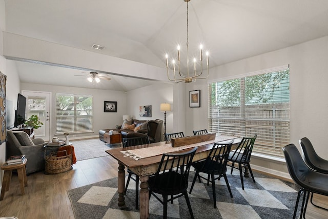 dining area with visible vents, wood finished floors, a wealth of natural light, and vaulted ceiling