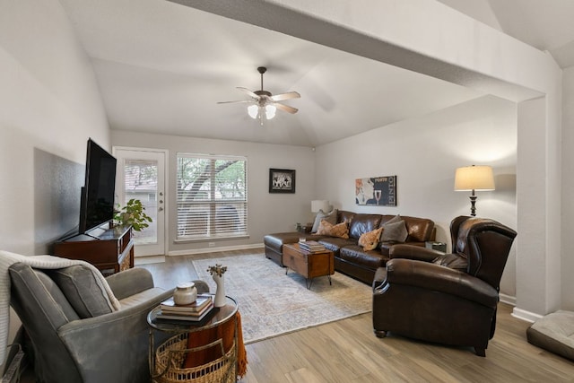 living area with baseboards, a ceiling fan, light wood-style flooring, and lofted ceiling