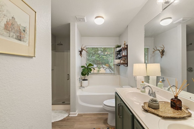 bathroom featuring a sink, a shower stall, wood finished floors, visible vents, and a garden tub