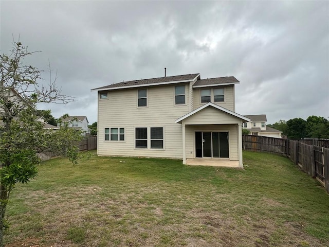 rear view of house featuring a fenced backyard, a yard, and a patio area