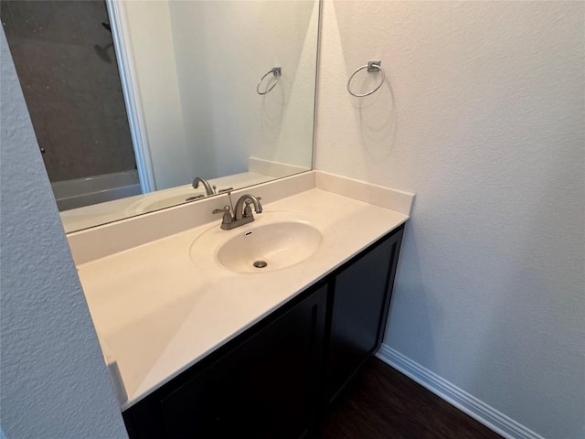 bathroom featuring vanity and a textured wall