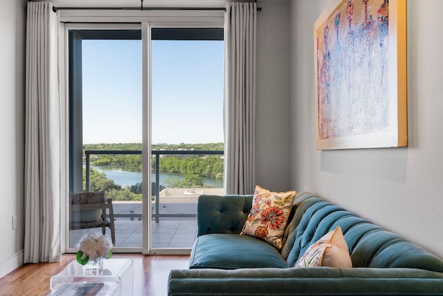 living area with a water view and wood finished floors