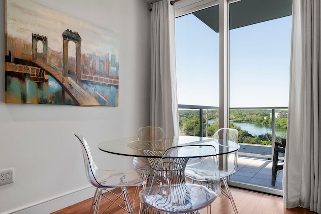 dining room featuring a water view and wood finished floors