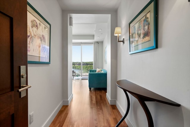 hallway with baseboards and wood finished floors