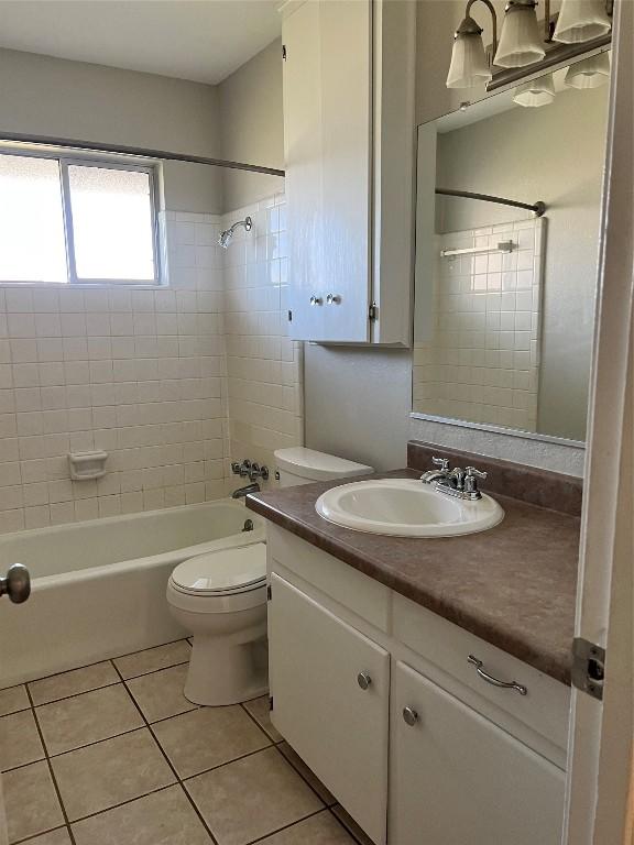full bath featuring vanity, tile patterned flooring, toilet, and  shower combination