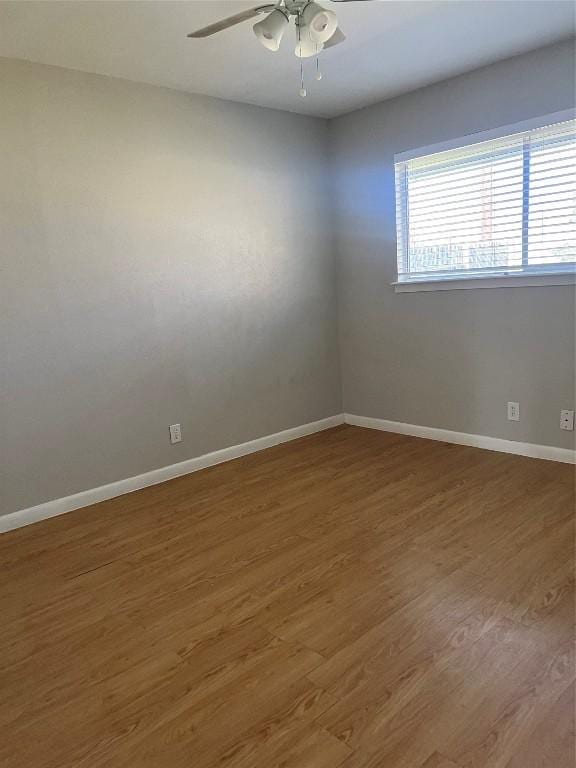 unfurnished room with baseboards, ceiling fan, and wood finished floors