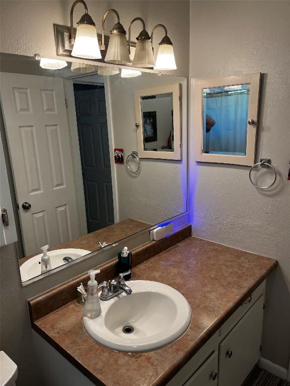 bathroom featuring vanity and a textured wall