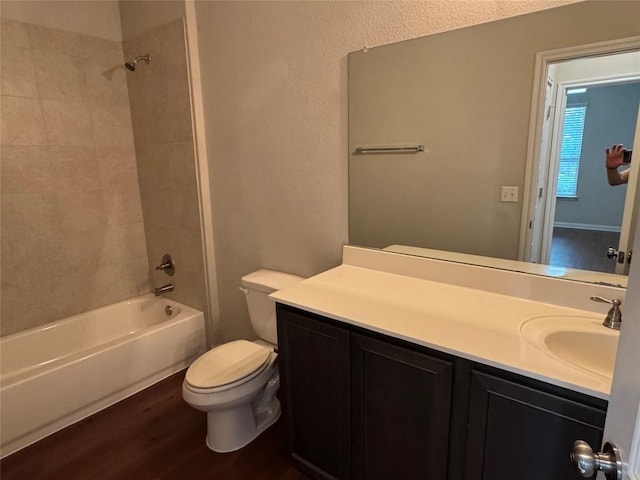 bathroom featuring vanity, tub / shower combination, wood finished floors, and toilet