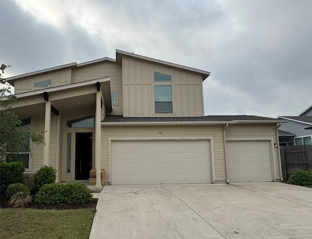 traditional-style home with an attached garage, fence, and concrete driveway