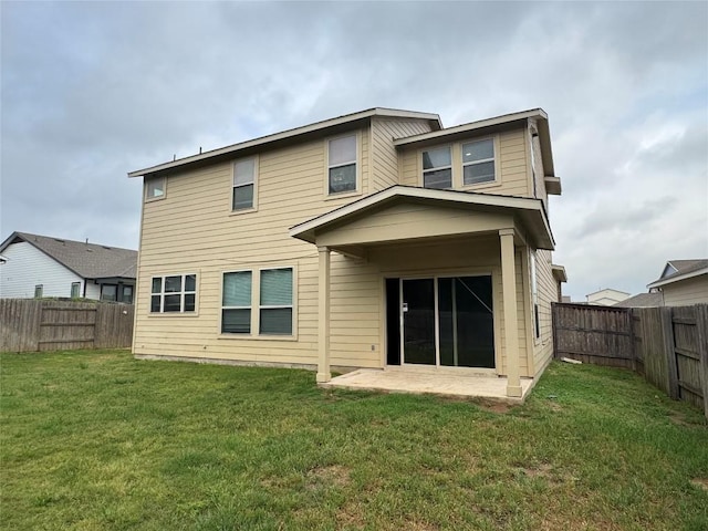 rear view of house featuring a fenced backyard, a patio, and a lawn