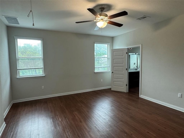 unfurnished bedroom with visible vents, dark wood-style flooring, baseboards, and multiple windows