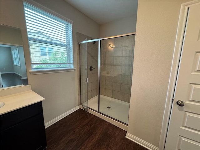full bathroom featuring vanity, baseboards, a shower stall, and wood finished floors