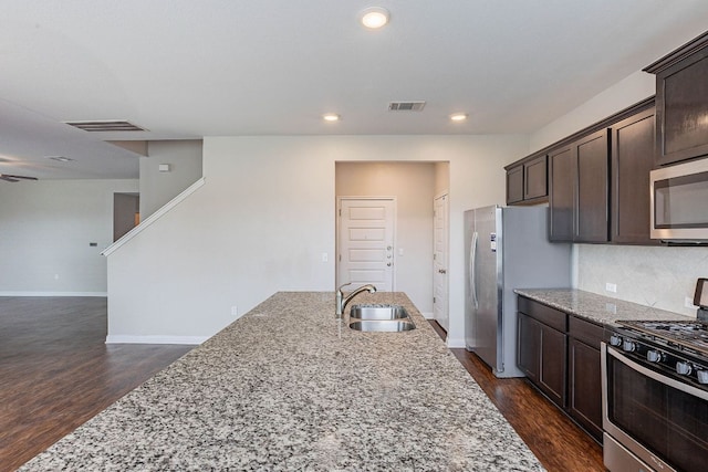 5816 Monmarte Cv, Austin, TX 78744 - kitchen with stainless steel appliances, a sink, dark brown cabinets, dark wood finished floors, and recessed lighting