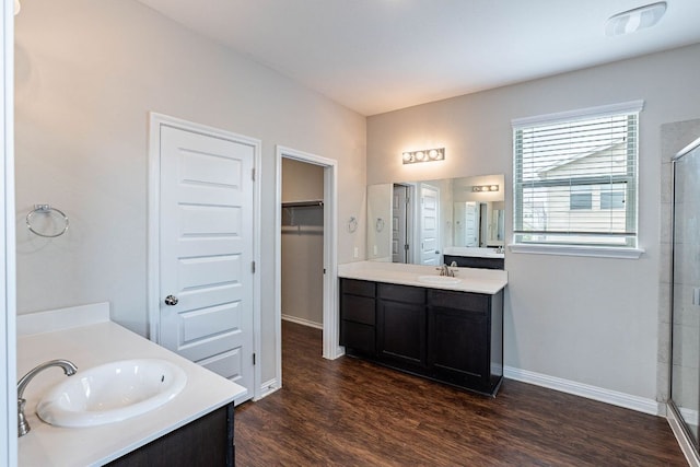 5816 Monmarte Cv, Austin, TX 78744 - full bathroom with two vanities, a shower stall, wood finished floors, and baseboards