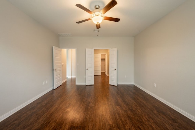 5817 Gerard Dr, Austin, TX 78744 - unfurnished bedroom featuring dark wood-style floors, a walk in closet, baseboards, and ceiling fan
