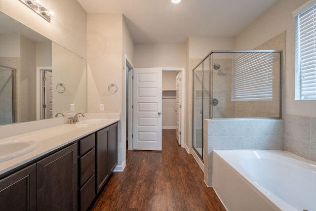5817 Gerard Dr, Austin, TX 78744 - bathroom with a shower stall, double vanity, wood finished floors, a garden tub, and a spacious closet