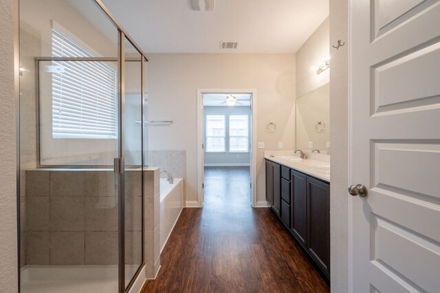 5817 Gerard Dr, Austin, TX 78744 - bathroom with wood finished floors, vanity, a stall shower, a bath, and ceiling fan
