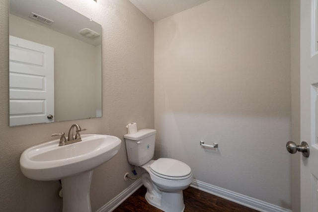 5817 Gerard Dr, Austin, TX 78744 - half bathroom featuring baseboards, toilet, and wood finished floors