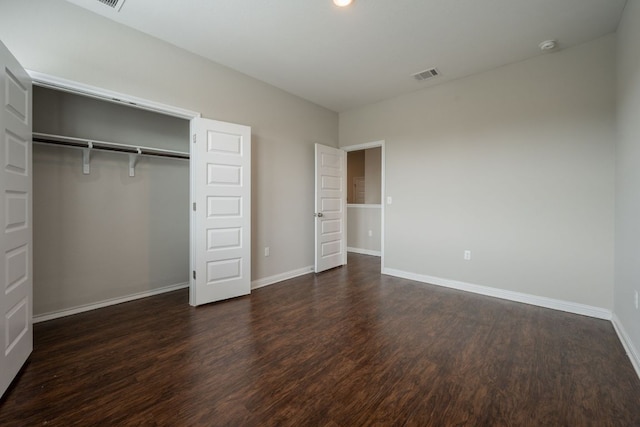 5817 Gerard Dr, Austin, TX 78744 - unfurnished bedroom with dark wood finished floors, baseboards, and a closet