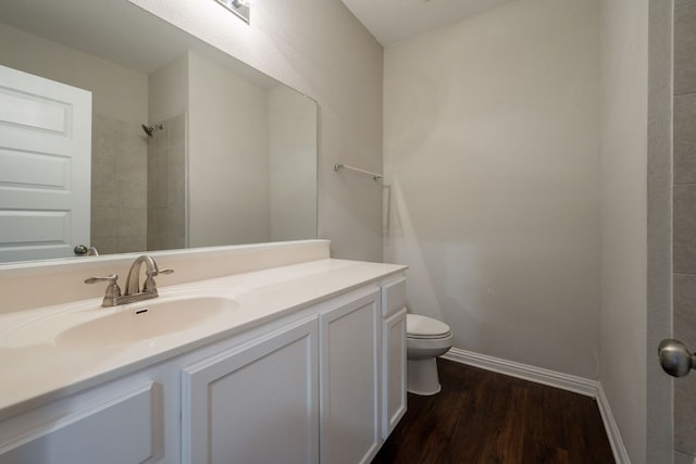 5817 Gerard Dr, Austin, TX 78744 - full bathroom with toilet, wood finished floors, vanity, baseboards, and a shower