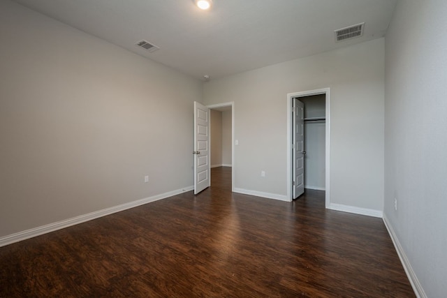 5817 Gerard Dr, Austin, TX 78744 - unfurnished bedroom featuring dark wood-style floors, baseboards, and a spacious closet
