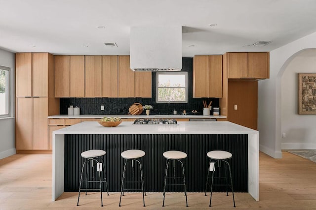 kitchen with light countertops, baseboards, light wood-type flooring, and tasteful backsplash