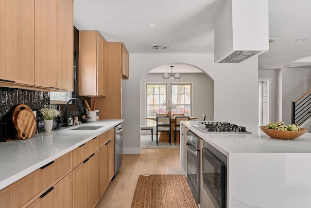 kitchen featuring visible vents, arched walkways, a sink, light countertops, and stainless steel appliances