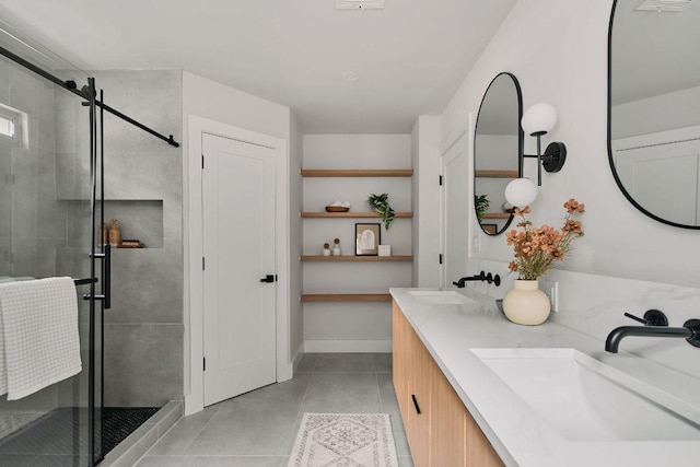 bathroom with double vanity, tile patterned floors, a shower stall, and a sink