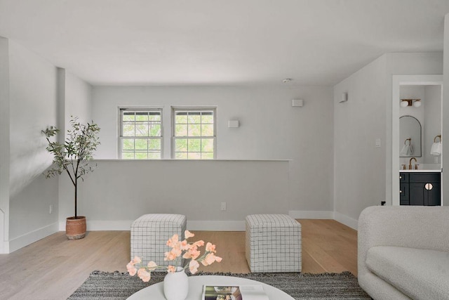 living area with baseboards and wood finished floors