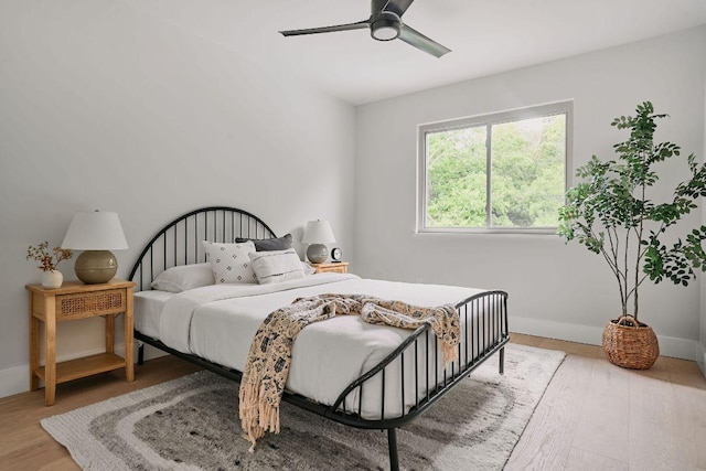 bedroom featuring baseboards, ceiling fan, and wood finished floors