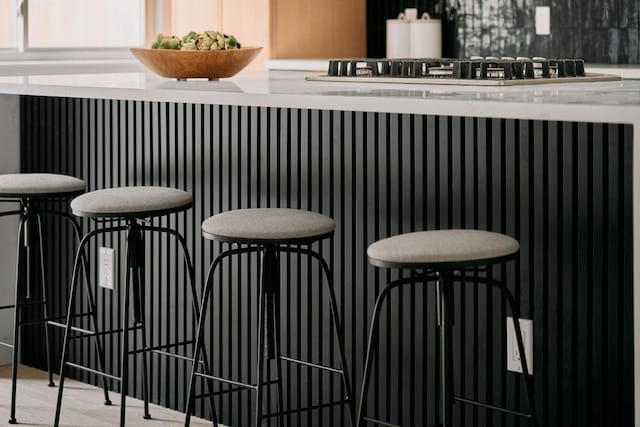 bar featuring backsplash and stainless steel gas cooktop