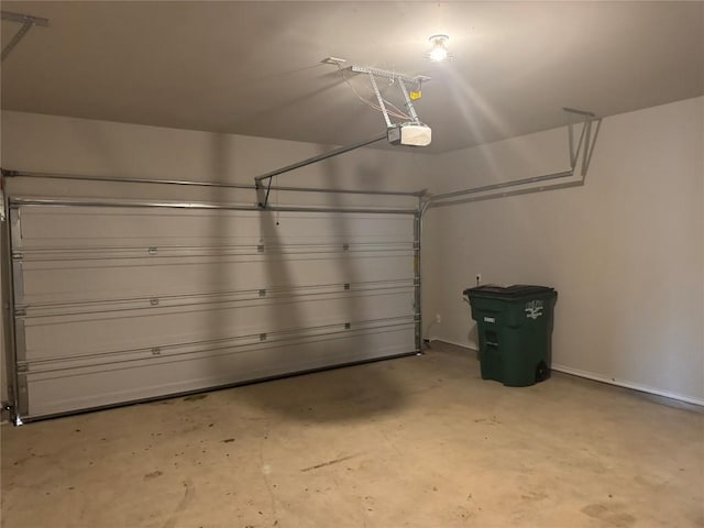 garage with baseboards and a garage door opener