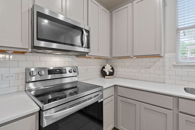 kitchen featuring light countertops, tasteful backsplash, and stainless steel appliances
