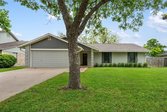 ranch-style house featuring fence, an attached garage, driveway, and a front yard