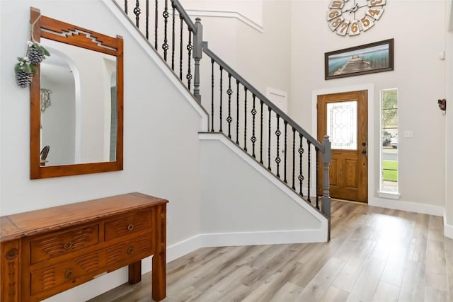 1400 Hargis Creek Trl, Austin, TX 78717 - foyer entrance with baseboards, light wood-style flooring, stairway, a high ceiling, and arched walkways
