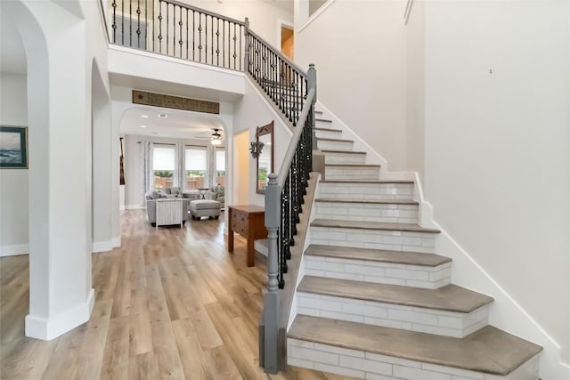 1400 Hargis Creek Trl, Austin, TX 78717 - staircase with arched walkways, wood finished floors, baseboards, a towering ceiling, and a ceiling fan