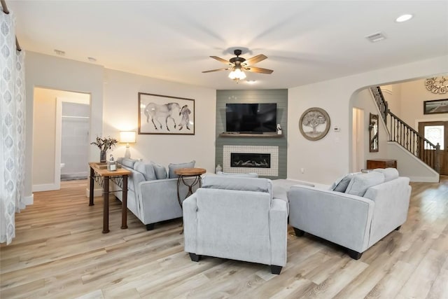 1400 Hargis Creek Trl, Austin, TX 78717 - living room featuring ceiling fan, light wood-style flooring, arched walkways, stairs, and a large fireplace