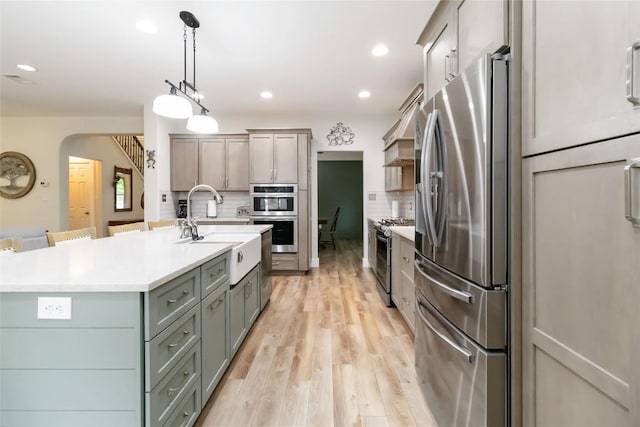 1400 Hargis Creek Trl, Austin, TX 78717 - kitchen with stainless steel appliances, a sink, backsplash, light countertops, and arched walkways