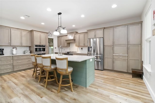1400 Hargis Creek Trl, Austin, TX 78717 - kitchen with stainless steel appliances, custom range hood, tasteful backsplash, a kitchen island with sink, and light countertops
