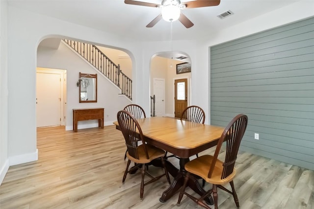 1400 Hargis Creek Trl, Austin, TX 78717 - dining space with arched walkways, a ceiling fan, light wood finished floors, and stairway