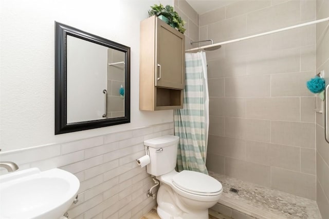 1400 Hargis Creek Trl, Austin, TX 78717 - full bathroom with a sink, a tile shower, toilet, tile walls, and a wainscoted wall