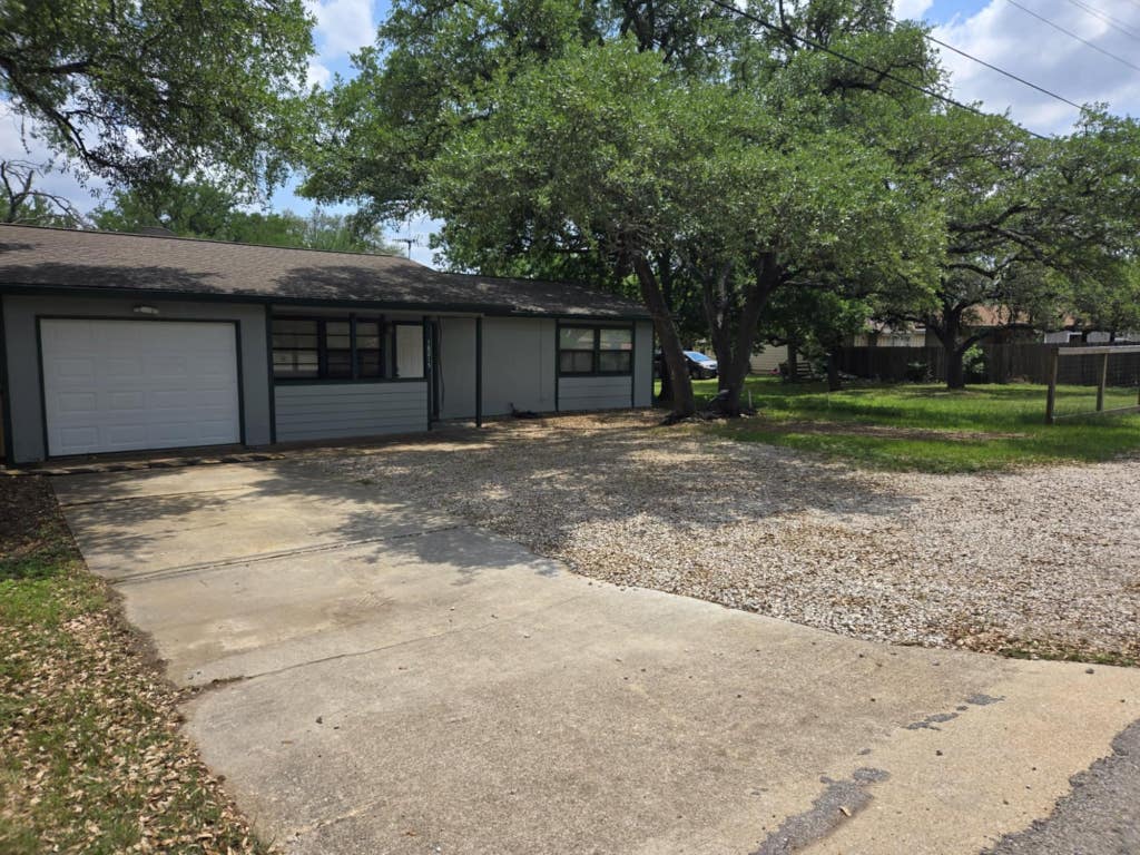 single story home featuring fence, an attached garage, and driveway