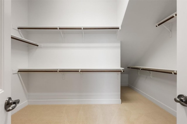 walk in closet featuring light colored carpet