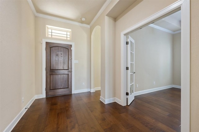 entryway with arched walkways, baseboards, ornamental molding, and dark wood-type flooring