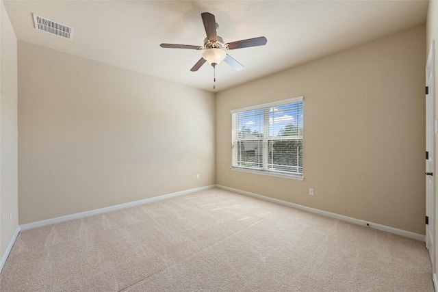 empty room with baseboards, visible vents, and light carpet