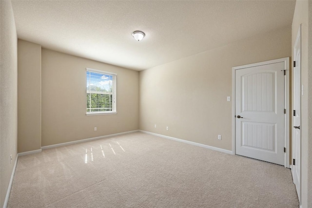 carpeted spare room with baseboards